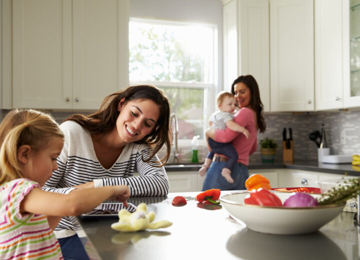 Familie på kjøkken med to kvinner og to barn