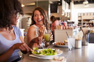 Kvinner spiser salat og smiler