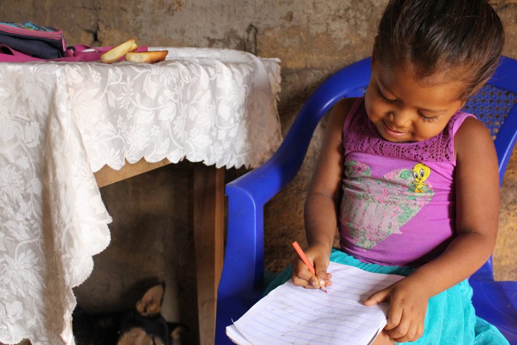 Liten jente i Nicaragua med skolebok