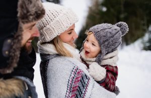 Familie med et lite barn ute i snøen