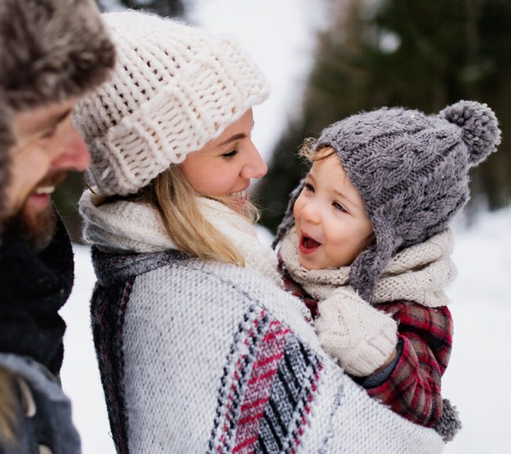 Familie med et lite barn ute i snøen